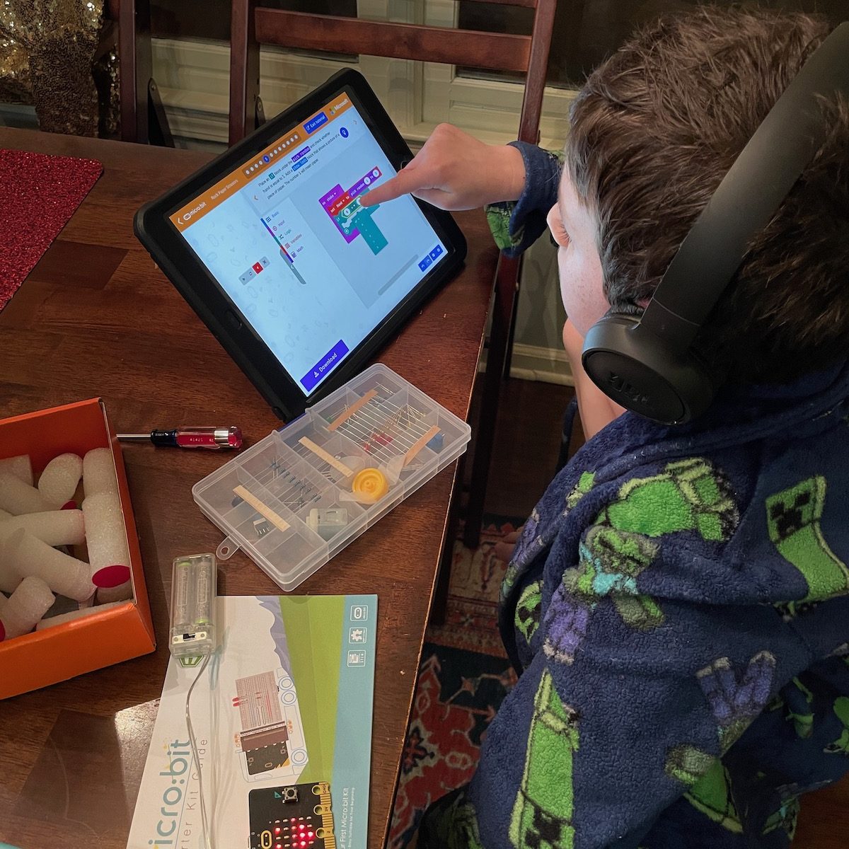 Overhead picture of a child coding and playing with electronics